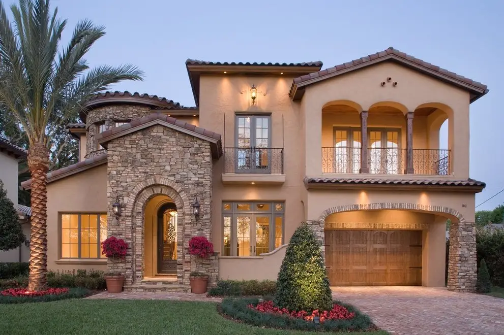 Spanish-style florida House taken at dusk with the lights on.